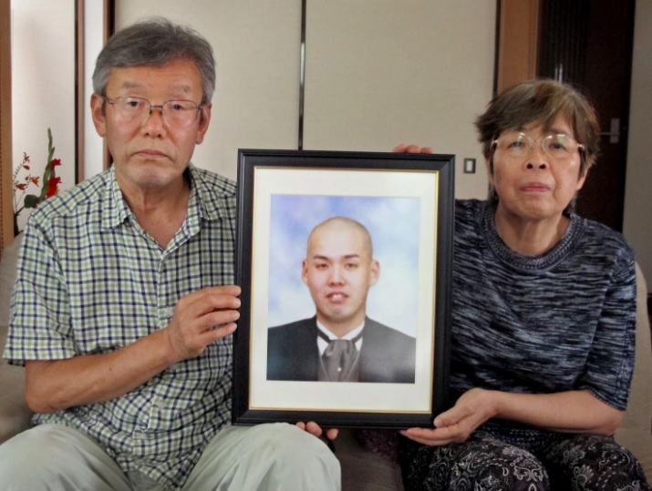 
Cha mẹ của Kiyotaka Serizawa cầm ảnh con sau đám tang
