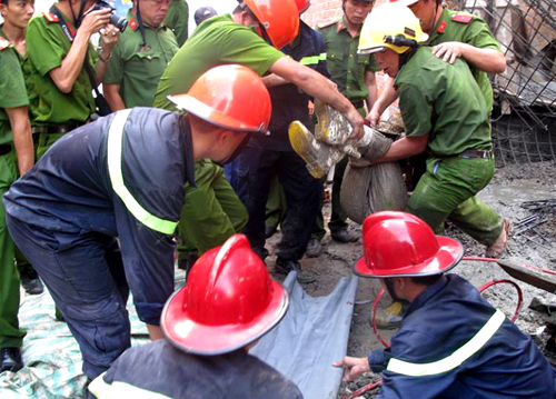 
Sau một giờ cắt b&ecirc;t&ocirc;ng v&agrave; sắt th&eacute;p, cảnh s&aacute;t cứu hộ đưa nạn nh&acirc;n bị v&ugrave;i lấp ra ngo&agrave;i. Ảnh: A.X

