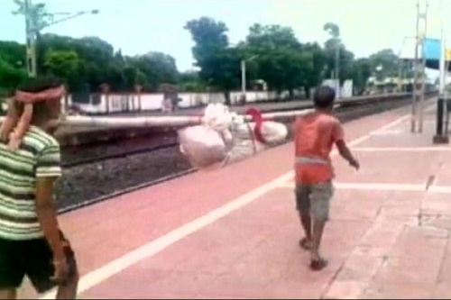
Xác bà cụ 80 tuổi được quấn lại và cáng tới ga xe lửa để chở đi khám nghiệm tử thi ở bệnh viện thành phố. Ảnh: India Express
