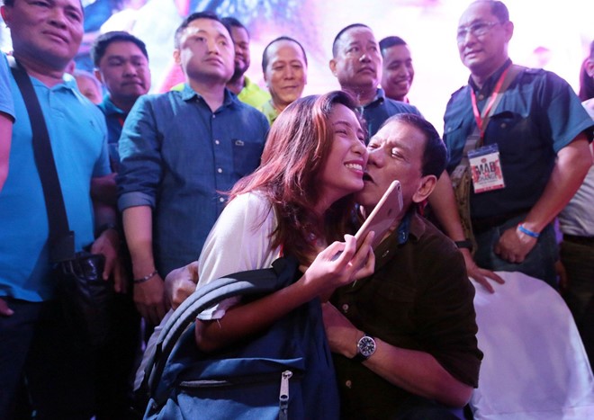 
Ông Duterte hôn má một người phụ nữ trong buổi vận động tranh cử tổng thống. Ảnh: Inquirer
