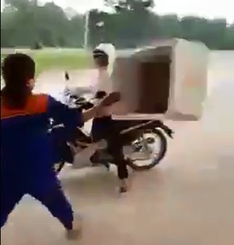 Nữ nh&acirc;n vi&ecirc;n c&acirc;y xăng d&ugrave;ng th&ugrave;ng xốp lao v&agrave;o đ&aacute;nh kh&aacute;ch khi bị tố gian lận. Ảnh: Cắt từ clip.
