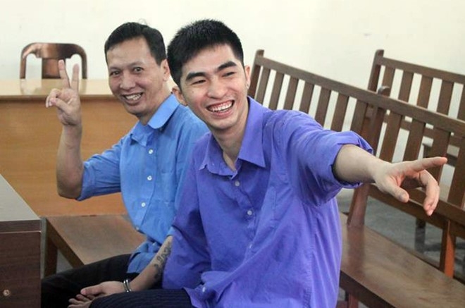 Hai bị cáo tươi cười, tạo dáng trước ống kính của phóng viên dù đang chờ bị tuyên án. Ảnh: Thăng Long.