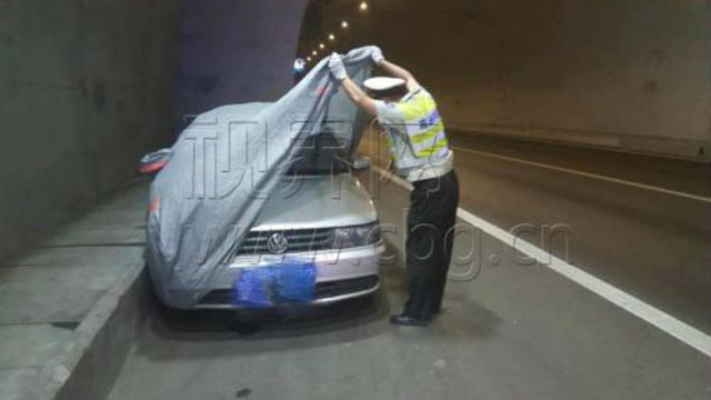 
Chiếc xe hơi phủ bạt, đậu trên làn đường khẩn cấp đã gây sự chú ý của cảnh sát. (Ảnh: CBG.cn)
