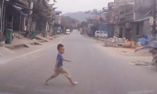 Bé trai băng qua đường.