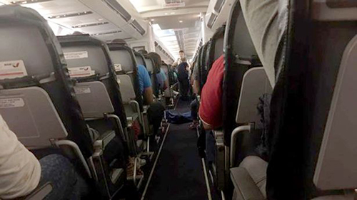 
Thi thể nữ hành khách được phủ chăn và đặt ở lối đi giữa hai hàng ghế trên chuyến bay. Ảnh: CEN
