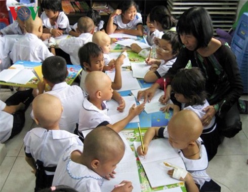 Cô Kim Phấn đang chỉ cho các bệnh nhi tập viết.