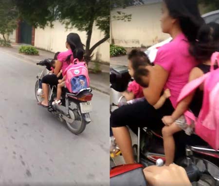 
Người phụ nữ đ&egrave;o 3 đứa trẻ, l&aacute;i xe bằng một tay, kh&ocirc;ng đổi mũ bảo hiểm v&agrave; cho con b&uacute;. (Ảnh cắt từ clip)
