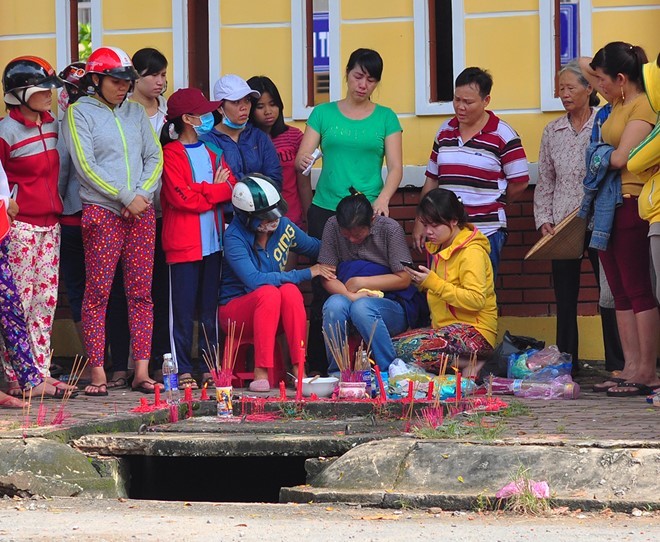 Người nhà bé trai mất tích thắp hương khu vực cống nước, than khóc thảm thiết. Ảnh: Ngọc An.