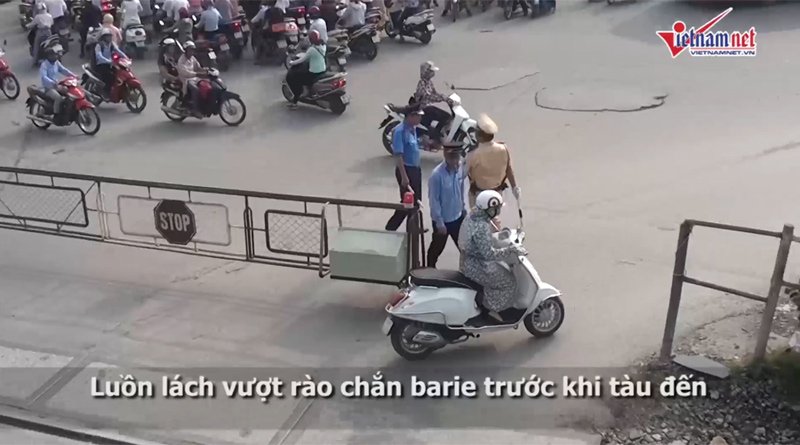 Một qu&yacute; c&ocirc; cố t&igrave;nh vượt d&ugrave; barie chắn t&agrave;u đ&atilde; được đẩy gần hết.