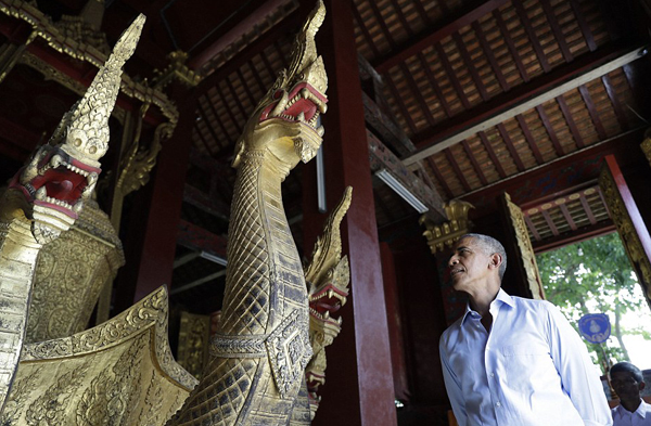 
Ông Obama dừng chân ngắm nhìn con thuyền mạ vàng, khắc hình rồng, được đặt bên trong chùa Wat Xieng Thong.
