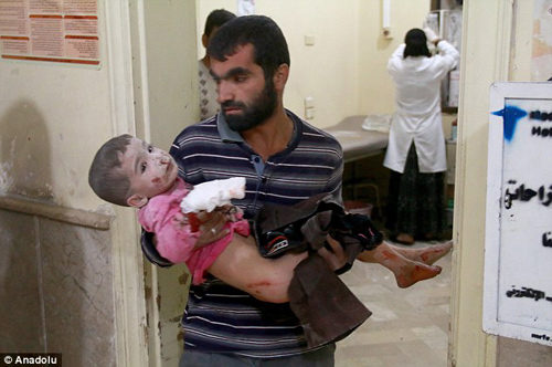 
Một người đ&agrave;n &ocirc;ng Syria mang con trai đến bệnh viện sau khi đứa nhỏ bị thương trong cuộc tấn c&ocirc;ng của qu&acirc;n đội Syria v&agrave; Nga v&agrave;o thị trấn Merce ở Aleppo
