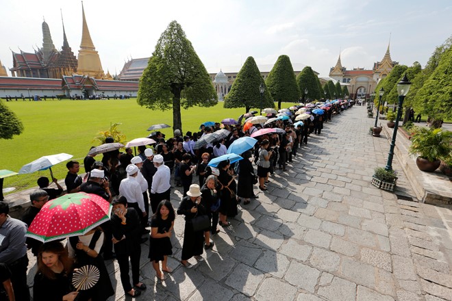 
Đoàn người xếp hàng chờ viếng Quốc vương Bhumibol tại Cung điện hoàng gia Thái Lan. Văn phòng trị sự Hoàng gia Thái Lan thông báo người dân có thể theo dõi nghi thức tắm gội truyền thống dành cho người quá cố tại sảnh Sahathai Samakhom trong Cung điện. Ảnh: Reuters.

