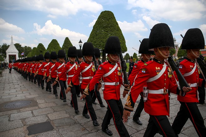 
Đội cận vệ tiến vào Cung điện hoàng gia trong lễ đón linh cữu Quốc vương Bhumibol. Đội quân này được thành lập từ năm 1859, có tên gọi thân mật là đội dọa quạ vì ban đầu họ làm nhiệm vụ xua đuổi những bầy quạ bay đến hoàng cung. Ảnh: Reuters.
