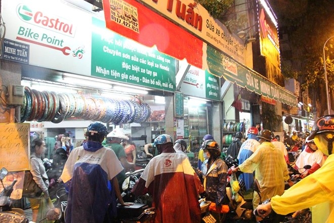 Người dân đem xe bị chết máy đến các điểm sửa xe trên đường Lê Hồng Phong, quận 10 lau chùi bugi. Ảnh:Lê Trai.