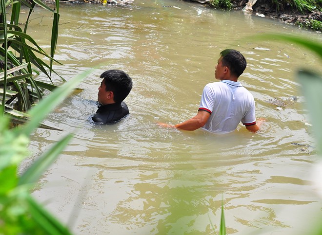Thợ lặn lực lượng cảnh sát phòng cháy chữa cháy Bình Dương và người dân lặn tìm bé Hiếu ở suối Nhum (khu vực giáp ranh thị xã Dĩ An và TP.HCM). Ảnh: Ngọc An.