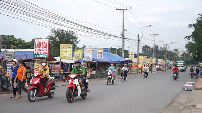 Chỉ một đoạn đường ngắn nhưng có hàng chục tấm bảng bán đồ ăn tại chợ đêm Làng đại học (quận Thủ Đức). Ảnh: Khải Trần.