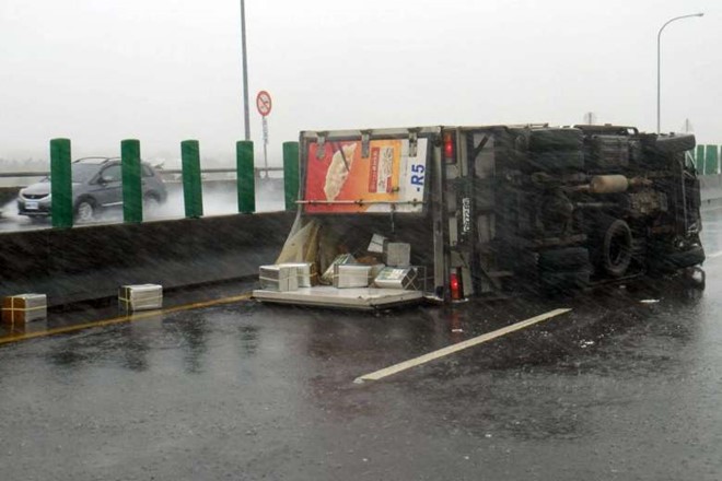 
Một chiếc xe tải bị gió bão quật ngã, nằm trên đường. Siêu bão Meranti mạnh ngang siêu bão Haiyan quét qua Philippines hồi năm 2013, khiến 7.000 người thiệt mạng. Ảnh: AFP.
