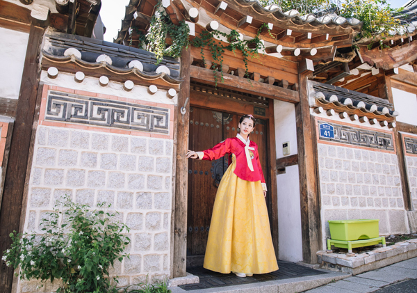 Chi Pu xúng xính trong trang phục hai màu đỏ và vàng, duyên dáng như nàng công chúa đi dạo ở làng cổ Hanok Bukchon.