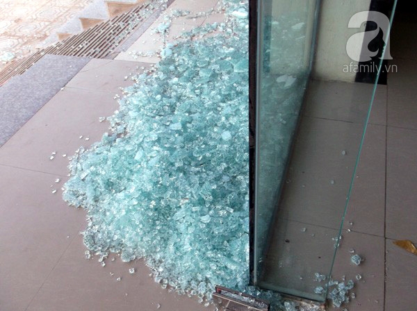 Cửa kính trước một tòa chung cư bị vỡ vụn sau khi có gió tác động.