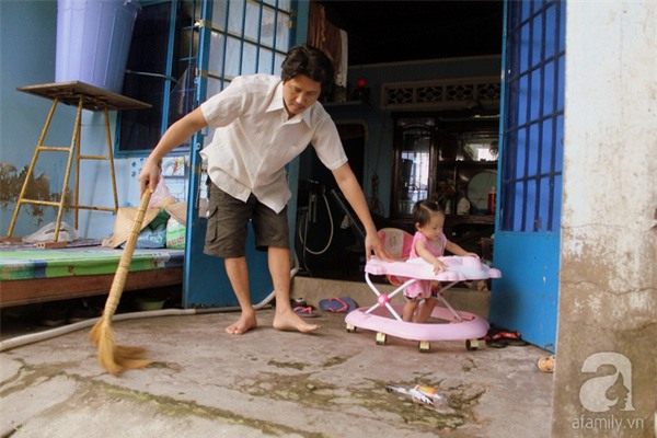 Anh Ba vừa quét nhà vừa trông con dù chẳng nhìn thấy gì.