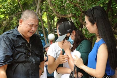 Cựu người mẫu Minh Anh (đội mũ, đeo khẩu trang) kh&oacute;c nức nở b&ecirc;n cạnh L&ecirc; Tuấn Anh v&agrave; Trịnh Kim Chi trong ng&agrave;y giỗ 20 năm L&ecirc; C&ocirc;ng Tuấn Anh