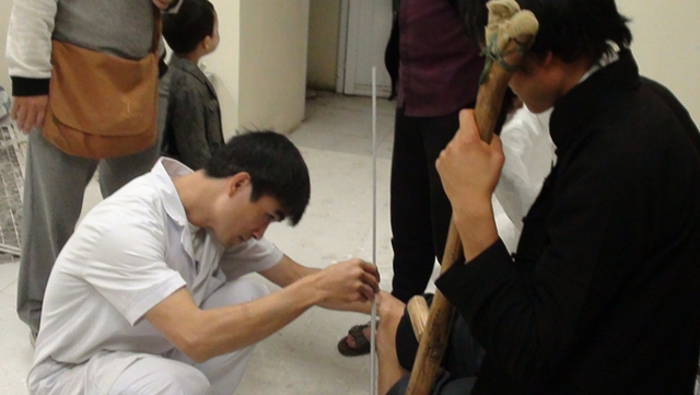 
BS - KTV Phạm Quang Trung đo chân làm chân giả cho anh Lùng. Ảnh: Thủy Hạnh
