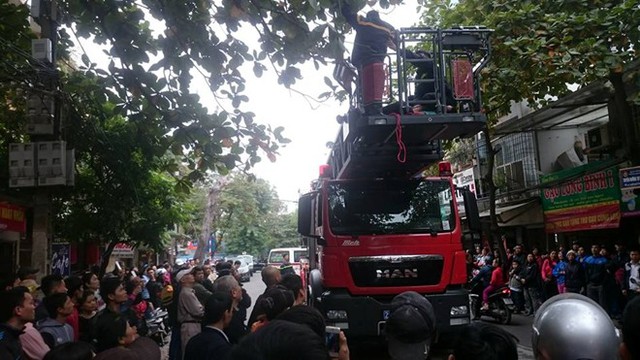 Người dân theo dõi cảnh sát giải cứu người đàn ông leo lên cây bàng đòi tự tử. Ảnh: Quân Nguyễn.