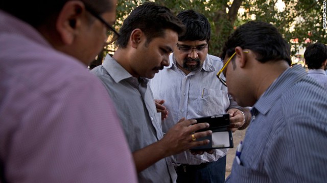
Người dân ở New Delhi đang xem thông tin về động đất trên điện thoại của họ
