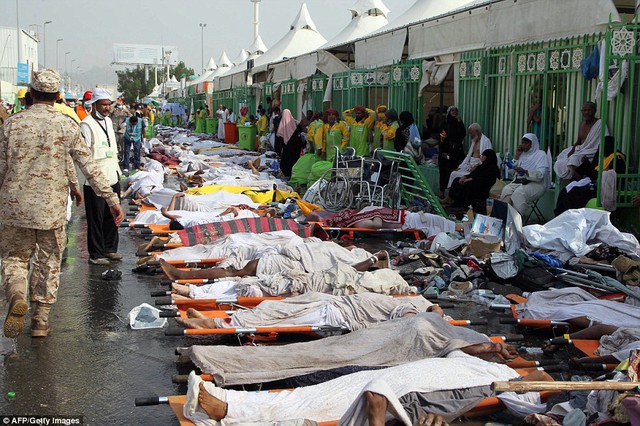 Horrific: Saudi emergency personnel stand near bodies of Hajj pilgrims at the site where at least 717 were killed  in a stampede that the Kingdoms health minister has blamed on the dead for not following instructions from the authorities