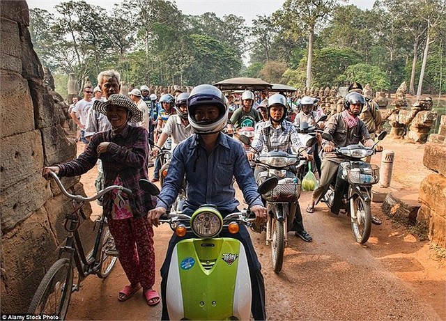 
Xe đạp, xe máy nối đuôi nhau xếp hàng dài vào giờ cao điểm ở Angkor Wat, Siem Reap, Campuchia.
