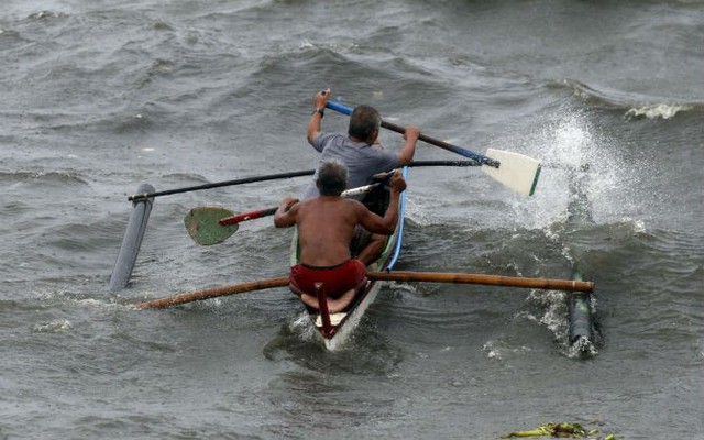 
Ngư dân chèo thuyền vào bờ khi cơn bão Koppu ập đến ở Vịnh Manila.
