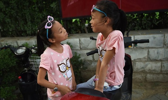 Hai chị em sinh đôi vui đùa ở Bắc Kinh, Trung Quốc. Ảnh: Getty