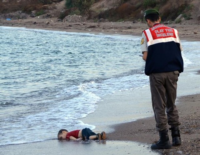 Thi thể Alan Kurdi, bé trai Syria 3 tuổi, dạt vào bờ biển gần khu nghỉ dưỡng Bodrum của Thổ Nhĩ Kỳ, sau khi thuyền chở người tị nạn dạt vào bờ ngày 2/9. Thuyền chở gia đình bé Aylan cùng những người khác gặp nạn khi đang trên đường tới đảo Kos, Hy Lạp. 14 người thiệt mạng và nhiều người khác mất tích trong tai nạn. Bức ảnh gây chấn động thế giới và khắc họa rõ nét nhất về thảm cảnh của người tị nạn. Ảnh: AP