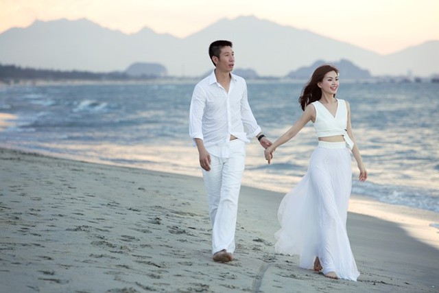 Trong ảnh, cặp vợ chồng sắp cưới cùng diện trang phục trắng tinh khiết, nắm tay nhau tình tứ, cùng đi dạo trên bờ biển về chiều. Khuôn mặt cô dâu rạng ngời niềm hạnh phúc.
