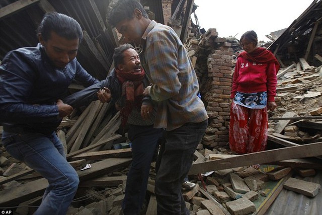 Người dân khóc khi hai thanh niên kéo ông ra khỏi ngôi nhà đổ nát tại Bhaktapur, Nepal sau trận động đất mạnh 7,9 độ Richter ngày 25/4. Thảm họa khiến 8.000 người chết và 16.000 người khác bị thương. Trận động đất cũng gây ra lở tuyết trên núi Everest làm 14 người thiệt mạng. Ảnh: AP