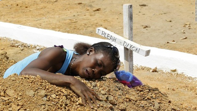 Một phụ nữ ôm nấm mồ em trai ở nghĩa trang quốc gia Liberia hôm 11/3. Nơi đây được xây dựng để chôn cất những người thiệt mạng vì nhiễm virus Ebola. Ảnh: CNN