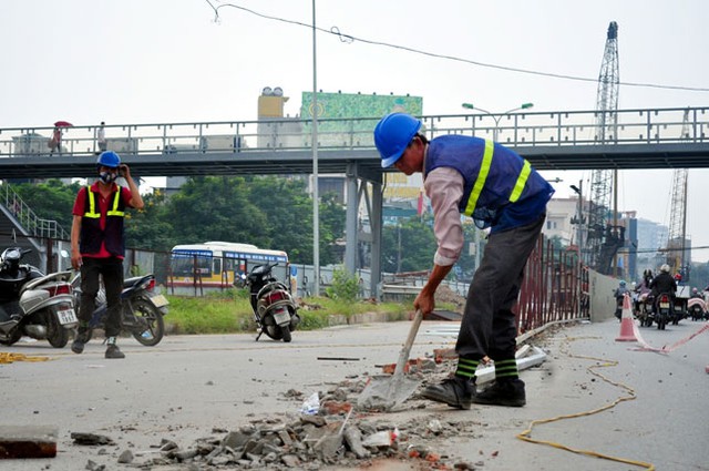 Công nhân dọn dẹp gạch, vữa rơi vãi trên đường để đảm bảo an toàn cho người đi đường.