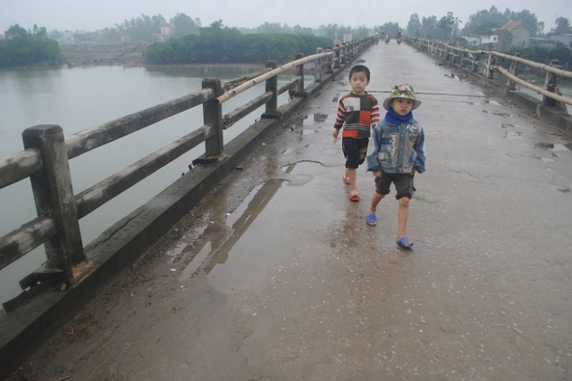 Những đứa trẻ vô tư đi qua cây cầu đầy nguy hiểm này.