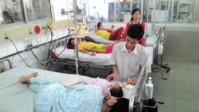 Bố mẹ bé Thanh Trúc, bệnh nhi nhỏ tuổi nhất tại phòng cấp cứu Khoa Sốt xuất huyết hôm 24/12, đang rất lo lắng cho con. Ảnh: Đ.B