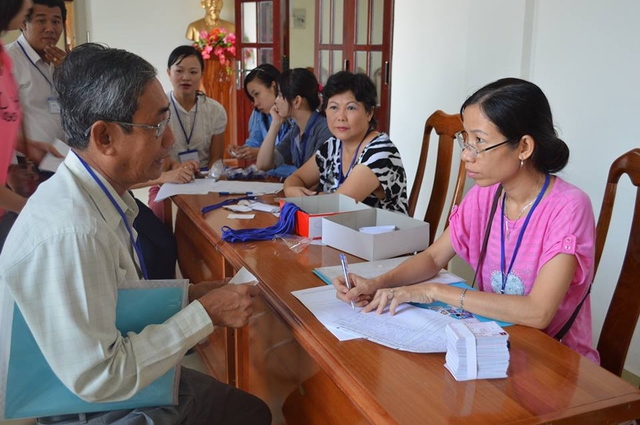 Chị Thư (bìa phải) tư vấn về chế độ bảo hiểm xã hội cho khách hàng.	Ảnh: Hưng Tân