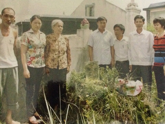 Thân nhân chiến sỹ Trần Văn Căn bên mộ phần ở khu Đồng Xìa, xã Đông Hải. Ảnh T.Thanh