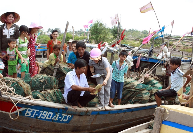 Cộng tác viên dân số phát tài liệu hướng dẫn ngư dân các biện pháp KHHGĐ.