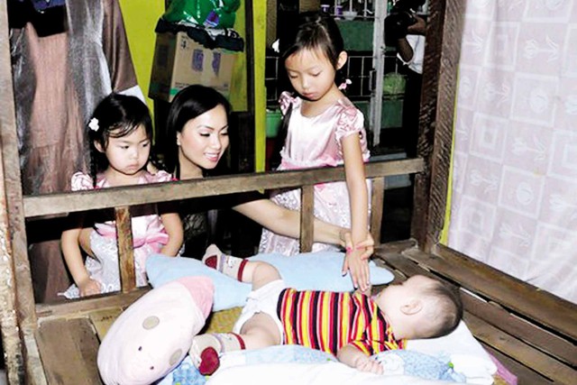 Ca sĩ Hà Phương và hai con gái trong một chuyến từ thiện. 	Ảnh: TL