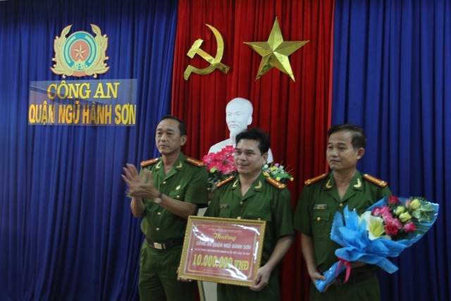 Đại tá Trần Mưu trao số tiền thưởng nóng cho Công an quận Ngũ Hành Sơn vào chiều 23/11. Ảnh Đức Hoàng
