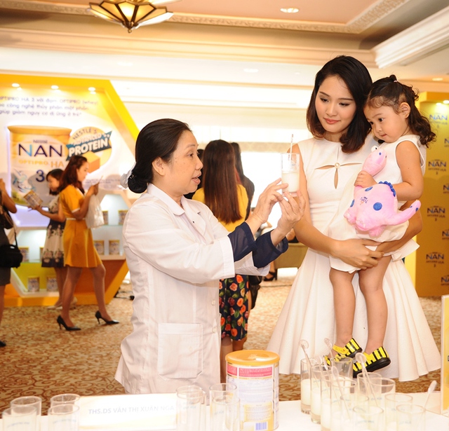 Hương Giang quan sát chuyên gia từ Nestlé Việt Nam đang thực hiện so sánh khả năng hòa tan của các loại đạm trong sữa