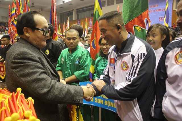 
Chủ tịch Liên đoàn Thế giới Võ cổ truyền Việt Nam Hoàng Vĩnh Giang trao cờ lưu niệm cho các đoàn tham dự

