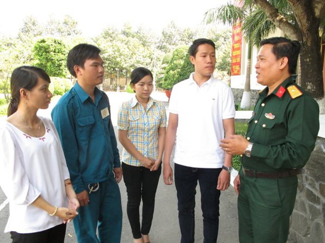 Bạn Trần Đại Dương (thứ hai từ phải) tìm hiểu một số thông tin từ thiếu tá Lê Bảo Trân, chính trị viên phó Ban chỉ huy quân sự quận 12 (TP HCM).