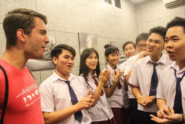 Các học sinh lớp 11A1 trường THPT An Dương Vương (TP.HCM) trò chuyện bằng tiếng Anh với anh Louis Kaloger, người Mỹ. Ảnh: Tuổi Trẻ.