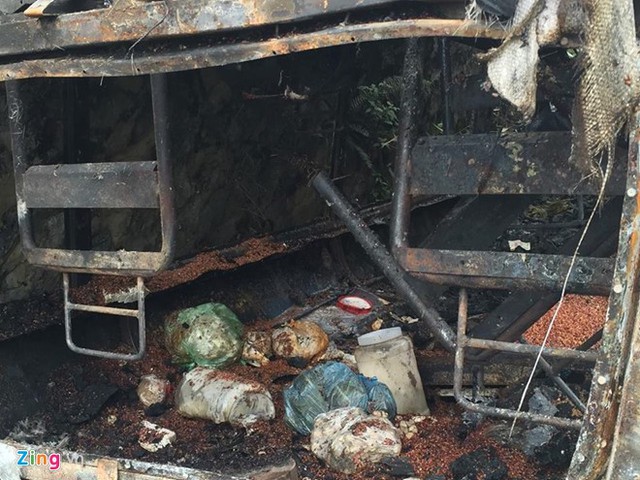 Trưa 15/3, chiếc xe khách bốc cháy trên đèo Thung Khe vẫn chưa được rời khỏi hiện trường. Trong xe nhiều đồ đạc, hành lý của các nạn nhân bị cháy xém. Ảnh: Hoàn Nguyễn.