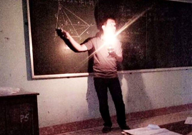 Hình ảnh thầy giáo cầm đèn dầu dạy học khiến nhiều người cảm động trước sự tận tâm của nhà giáo. Ảnh: Facebook.